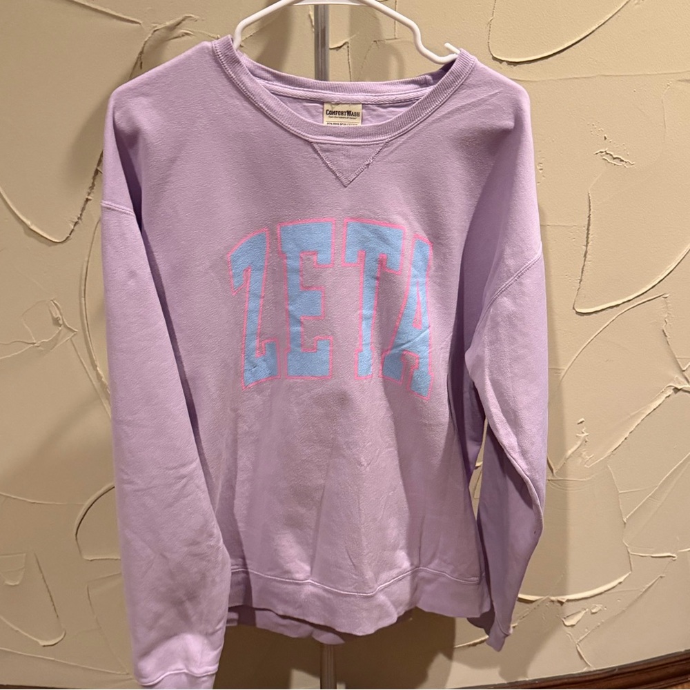 Purple crewneck sweatshirt with blue 'ZETA' text